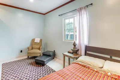 a bedroom with a bed and a chair and a window at Game Room and Fire Pit Quiet Family Home in Bonita in Bonita
