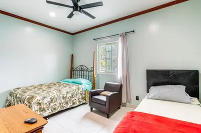 a bedroom with two beds and a chair and a window at Game Room and Fire Pit Quiet Family Home in Bonita in Bonita