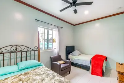 a bedroom with two beds and a chair at Game Room and Fire Pit Quiet Family Home in Bonita in Bonita