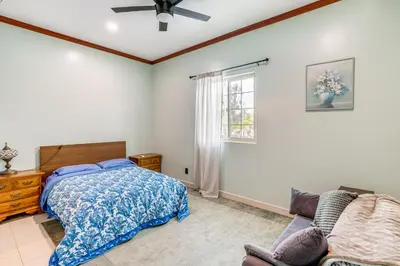 a bedroom with a bed and a couch and a window at Game Room and Fire Pit Quiet Family Home in Bonita in Bonita