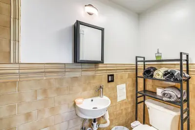 a bathroom with a sink and a toilet and a mirror at Game Room and Fire Pit Quiet Family Home in Bonita in Bonita