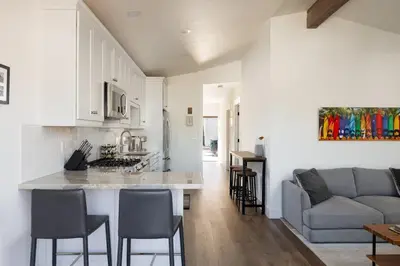 a kitchen and living room with a couch and a table at 2BD Sashas Bungalow Beach Vibes 1 Block Away in San Diego