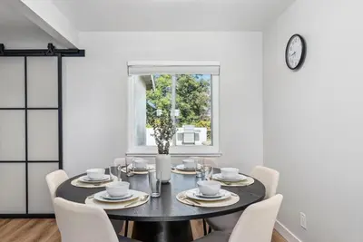 a dining room with a table with chairs and a clock at NEW Cozy Zen Pool Jacuzzi Home Heart of San Diego in San Diego