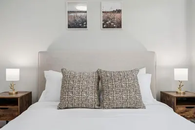 a bedroom with a white bed with two night stands at NEW Cozy Zen Pool Jacuzzi Home Heart of San Diego in San Diego