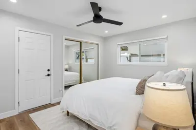 a white bedroom with a bed and a ceiling fan at NEW Cozy Zen Pool Jacuzzi Home Heart of San Diego in San Diego
