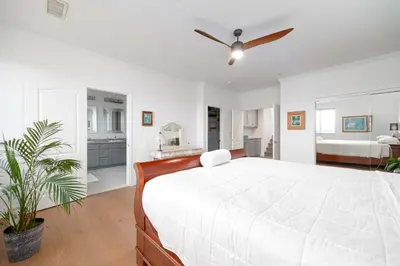 a white bedroom with a large bed with a ceiling fan at Water Views on Every Floor for this multi Holiday Home - Walk to the Beach in Carlsbad