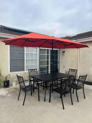 a black table with chairs and a red umbrella at 15 Min from Torrey Pines State Beach and Golf in San Diego