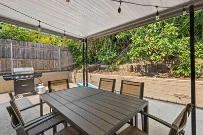 a patio with a table and chairs and a grill at 15 Min to Beach and Zoo - Hot Tub - Cozy Fire Villa Pit in San Diego