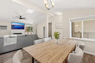 a dining room with a table and a couch at 15 Min to Beach and Zoo - Hot Tub - Cozy Fire Villa Pit in San Diego