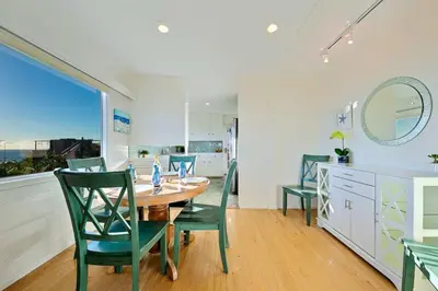 a dining room with a table and green chairs at Ocean Views Walk to the Beach with King Suite in Encinitas