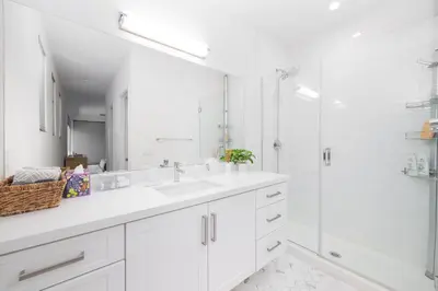 a white bathroom with a shower and a sink at Walk to Balboa Park and Little Italy LUX Townhome in San Diego