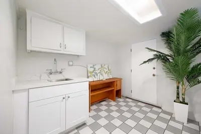 a kitchen with white cabinets and a potted plant at Sunset Balcony Views 1 Mile to Beach 7 Beds in San Diego