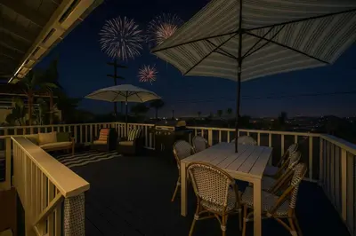 a deck with chairs and a table with an umbrella at Sunset Balcony Views 1 Mile to Beach 7 Beds in San Diego