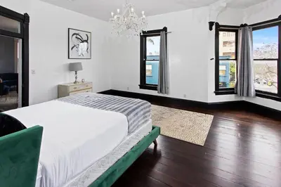 a bedroom with a bed and two windows at 1900's Victorian Home Sleeps 22 8BDRM 3Bath in San Diego