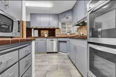 a large kitchen with white cabinets and appliances at Hilltop Villa Offering Uninterrupted Ocean Vistas in San Diego