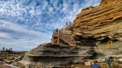 people standing on a cliff with a staircase on it at Hilltop Villa Offering Uninterrupted Ocean Vistas in San Diego