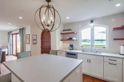 a kitchen with white cabinets and a chandelier at Casa Hermosa in San Diego