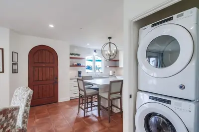 a kitchen with a washer and dryer next to a table at Casa Hermosa in San Diego