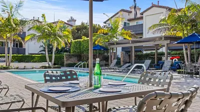 a table with chairs next to a swimming pool at Close to Beach w Patio Resort Amenities The Point at Corniche by AvantStay STR16-0458 in Dana Point