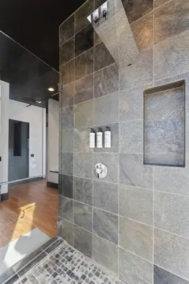 a bathroom with a shower with a stone wall at Secluded Dream Home with Hot Tub and Full Gym on 20 Acres in Palomar Mountain