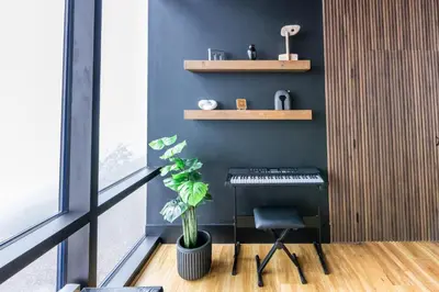 a room with a piano and a chair and a plant at Secluded Dream Home with Hot Tub and Full Gym on 20 Acres in Palomar Mountain