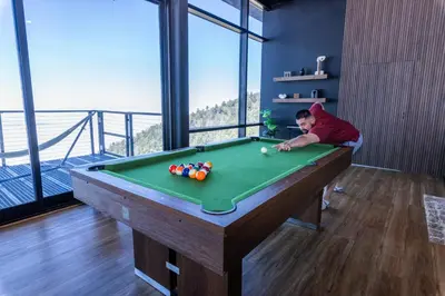 a young boy playing pool in a room with a pool table at Secluded Dream Home with Hot Tub and Full Gym on 20 Acres in Palomar Mountain