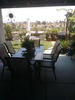 a dining room table with chairs and a laptop on it at Comfortable Home in San Diego Lemon Grove Area in Lemon Grove