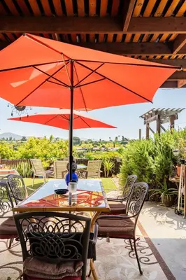 a table with a red umbrella on a patio at Comfortable Home in San Diego Lemon Grove Area in Lemon Grove