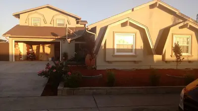 a white house with a porch and a driveway at comfortable home in San Diego Lemon Grove area in Lemon Grove