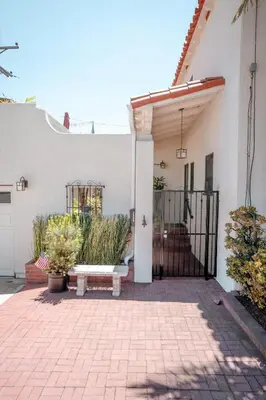 a white house with a gate and a bench at Charming Casita with City and Bay Views in San Diego