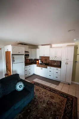 a kitchen with white cabinets and a blue couch at Charming Casita with City and Bay Views in San Diego