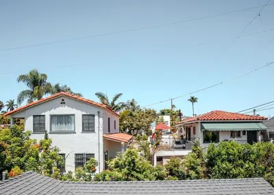 a large white house with trees in the background at Charming Casita with City and Bay Views in San Diego