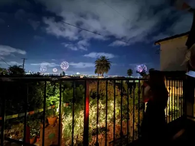 a person walking on a balcony looking at the christmas lights at Charming Casita with City and Bay Views in San Diego