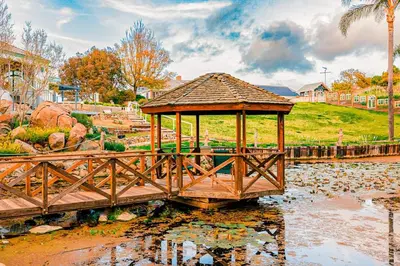 a wooden gazebo in the middle of a pond at Enchanted Estate With Animals Lightscapes and Whimsy in Bonsall