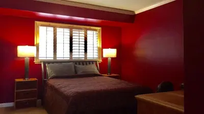 a bedroom with red walls and a bed with two lamps at Room in Bay Park, San Diego in San Diego