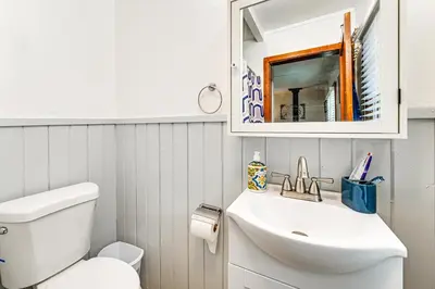 a bathroom with a toilet and a sink and a mirror at Near Hiking and Mtn Biking Cozy Cabin in Mt Laguna! in Mount Laguna