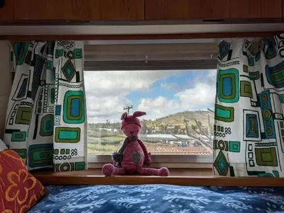 a teddy bear sitting on a window sill at Artsy Airstream for a California Glamping Weekend near San Diego in San Marcos