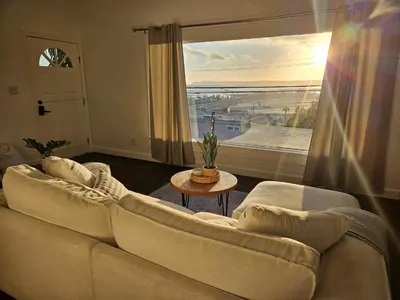 a living room with a couch and a large window at Eagle's Nest - Hot Tub & Stunning Bay View - Walk To Little Italy in San Diego