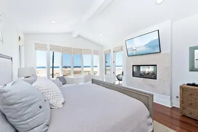 a white bedroom with a bed and views of the ocean at Oceanfront Escape with Breathtaking Views in Newport Beach