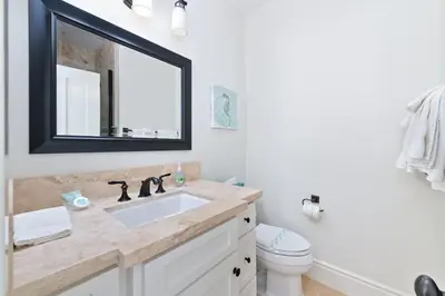 a bathroom with a sink and a mirror and a toilet at Oceanfront Escape with Breathtaking Views in Newport Beach