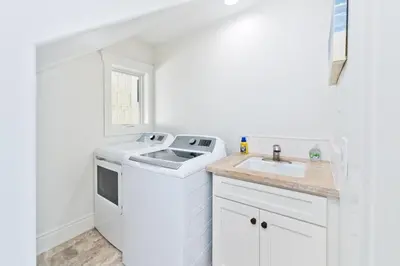 a white kitchen with a sink and a dishwasher at Oceanfront Escape with Breathtaking Views in Newport Beach