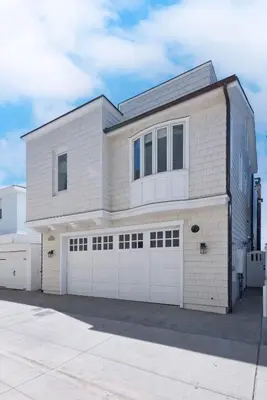 a white brick house with two garage doors at Oceanfront Escape with Breathtaking Views in Newport Beach