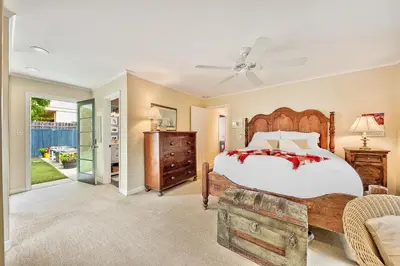 a bedroom with a large bed and a couch at Sunny Gardens A Classic La Jolla Beach Home Close to Wind n Sea Beach in San Diego