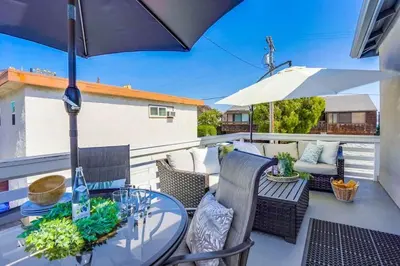 a patio with a table and chairs and an umbrella at Bali Beach in San Diego