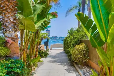 a walking path with palm trees and a body of water at Bali Beach in San Diego