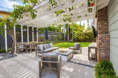 a patio with a pergola and tables and chairs at Leucadia Paradise in Encinitas