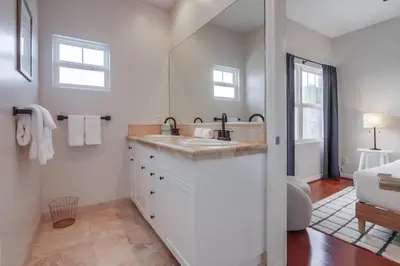 a white bathroom with a sink and a mirror at Leucadia Paradise in Encinitas