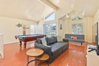 a living room with a couch and a pool table at Seas the Fun in Newport Beach