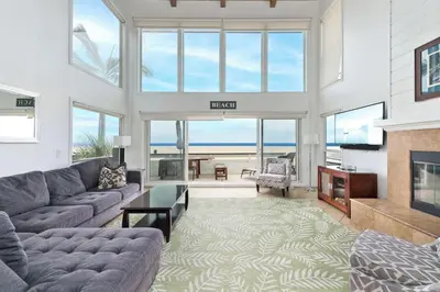 a living room with a couch and a fireplace at Spacious Oceanfront Home Near Newport Pier in Newport Beach
