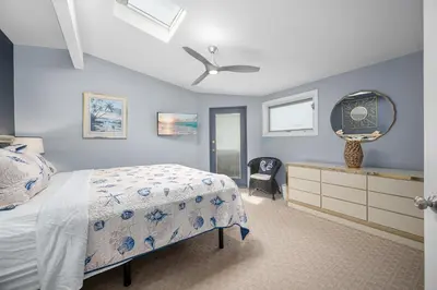 a bedroom with a bed and a dresser and a mirror at Luxurious Oceanfront Home with Incredible Views in Newport Beach